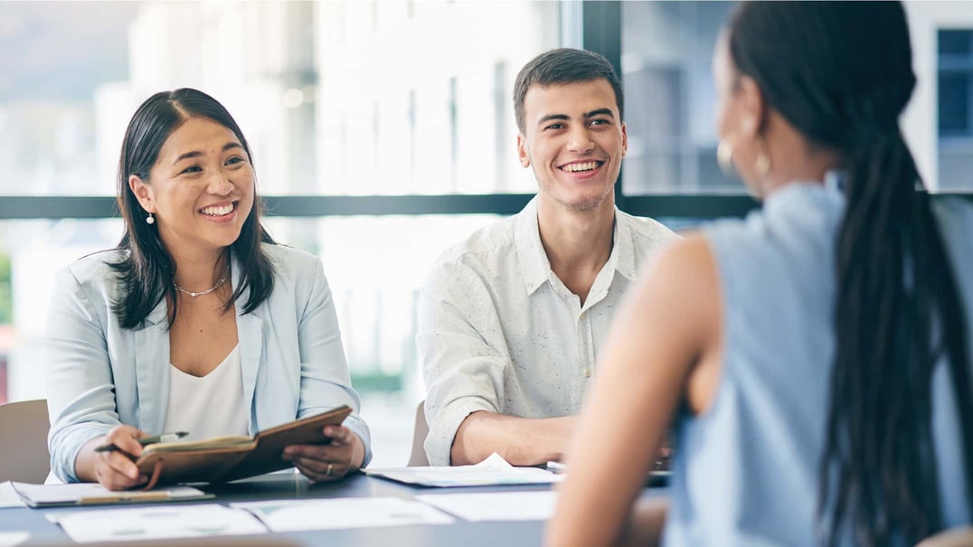 Broker meeting with employer clients while reviewing ancillary and supplemental employee benefits options.
