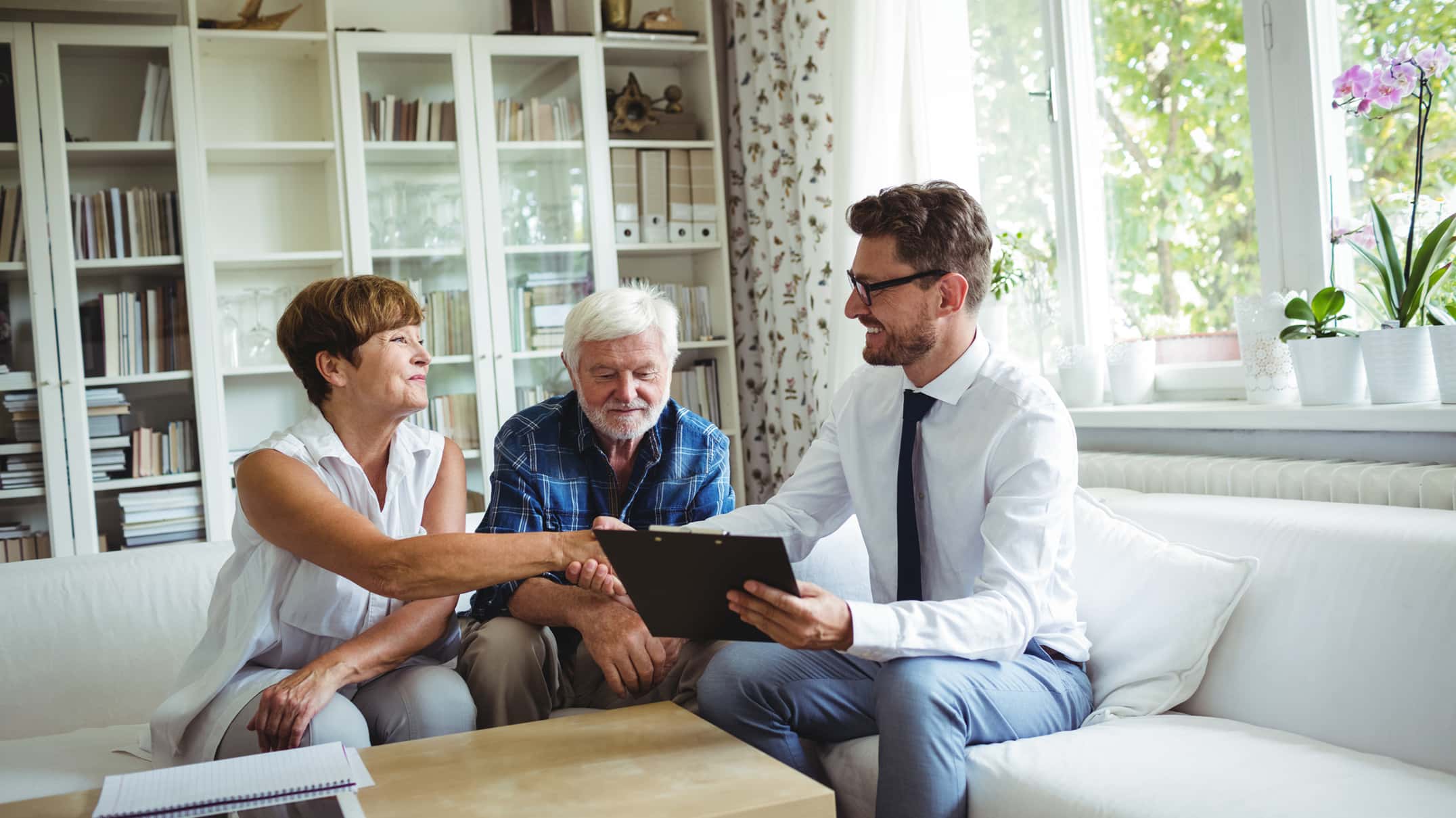 Older adult couple meeting with an insurance advisor to review Medicare coverage options.
